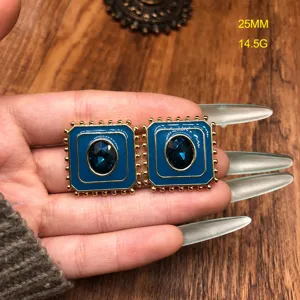 Gros plan détaillé de boucles d'oreilles carrées émaillées vintage en pierre précieuse bleue.