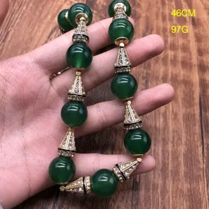 Vintage green agate necklace detail showing ornate rhinestone gold cone beads and magnetic clasp.