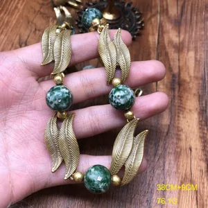 Vintage retro style green stone necklace with metallic leaf design, chic jewelry accessory.