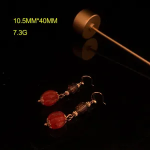 Detailaufnahme von Vintage-Kürbis-Glasperlen-Ohrringen, eleganter Retro-Metallschmuck.