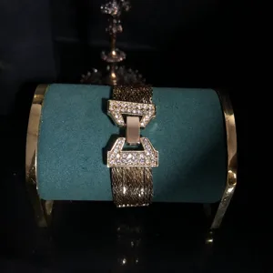 Detailed close-up shot of multi-strand rhinestone gold plated bracelet on display stand