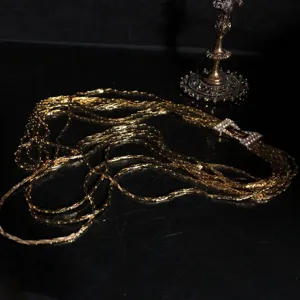 Detailed view of the multi-strand gold plated chain necklace with rhinestones and sparkly gems.