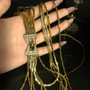 Multi-strand gold plated copper chain necklace with rhinestone buckle detail close-up