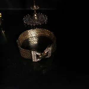 Gold plated multi-strand mesh bracelet detailed view with sparkling rhinestone geometric clasp close up.