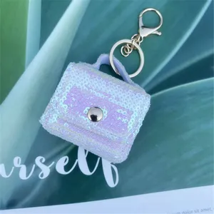 Macro detail of iridescent sequin mini bag keychain with silver hardware