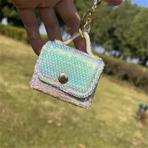 Close-up of iridescent sequin mini bag keychain with gold-tone metal clasp details.