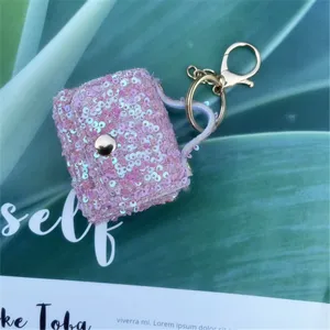 Detailed close-up of a pink sequined mini bag keychain with elegant gold-tone hardware.