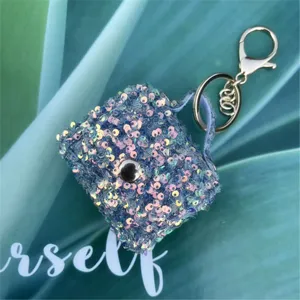 Close-up of a mini bag keychain charm adorned with shimmering iridescent blue sequins.