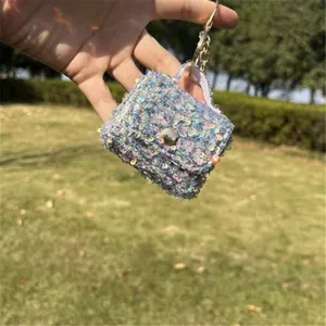 Close-up view of a sparkling sequin mini bag keychain charm featuring a golden ring