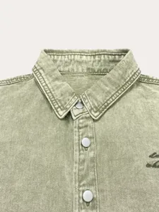 Heren casual lichtgroene denim jas kraag detail met drukknopen en fijne textuur.