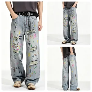 Loose straight washed blue jeans with artistic graffiti prints and distressed rips for street style.