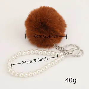 Brown faux fur pompom and white pearl strap keychain detail showing dimensions and weight.