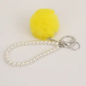 Cute yellow plush pom pom pearl bracelet keychain detail view showing fuzzy ball and metal rings