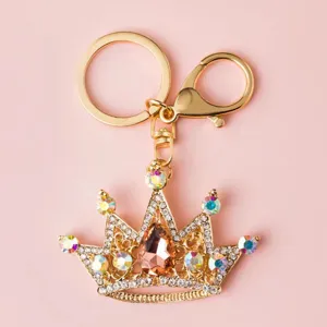 Rhinestone crown keychain detail, golden metal bag charm with colorful crystals and sparkling diamonds.