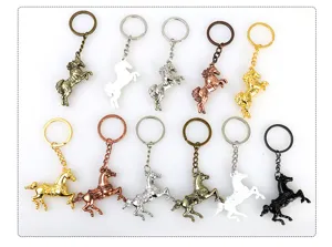 Detailed shot of various metal horse keychains in multiple metallic colors and finishes.