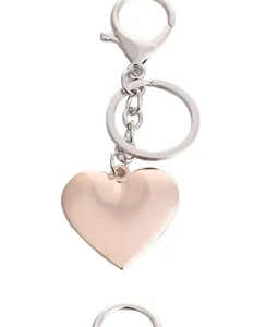 Metal heart keychain pendant with lobster clasp and keyring in rose gold finish detail shot.