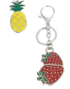 Close up detail view of cute metal fruit keychain featuring pineapple and glitter strawberry.