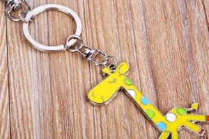 Metal giraffe keychain detail shot, alloy cartoon animal keyring pendant accessory display.