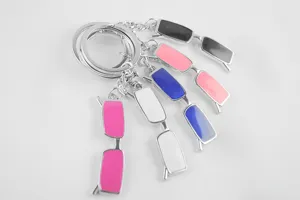 Close-up detail shot of miniature glasses keychains with colorful metal frames and dual rings.