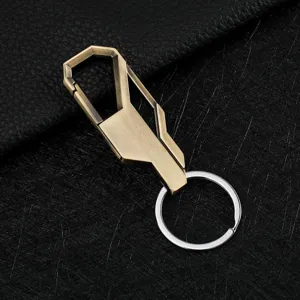 Close-up detail of the metal geometric carabiner keychain, showing fine bronze and silver finish.
