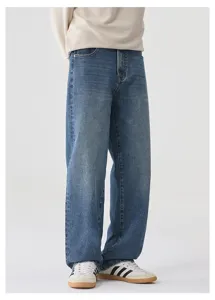 Primo piano dettaglio di jeans denim blu lavaggio vintage a gamba dritta con sneakers.