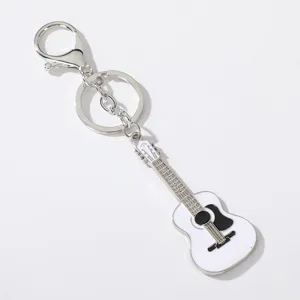 Detail shot of the metal guitar keychain pendant with white and black enamel finish close up