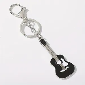 Detailed close-up of a stylish metal guitar keychain with black and silver finish.