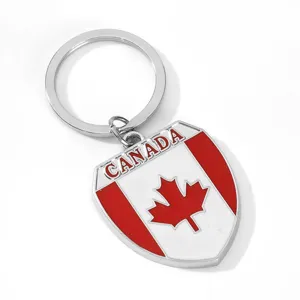 Close-up detail of the metal shield keychain featuring Canadian flag design and lettering.