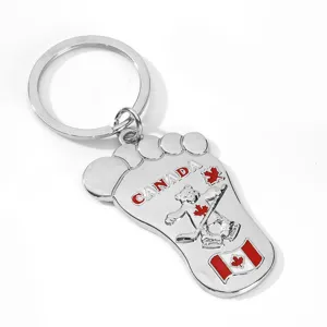 Detailed close-up of the metal Canada flag footprint keyring featuring maple leaf and bear.