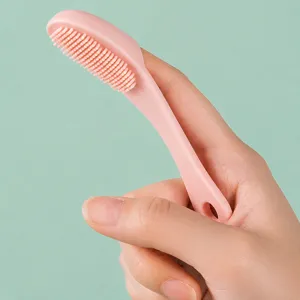 Pink silicone finger facial cleansing brush for blackhead removal and gentle pore exfoliation.