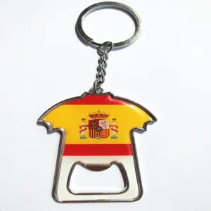 Dettaglio in primo piano del portachiavi apribottiglie in metallo a forma di maglia Spagna.