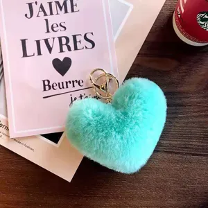 Mint green heart plush keychain detail, fluffy rabbit fur pom pom bag charm with gold clasp