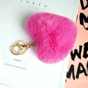 Fluffy pink heart plush keychain and bag charm with gold metal clasp for accessories.