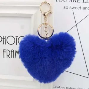 Blue fluffy heart plush keychain detail shot, soft faux rabbit fur bag pendant accessory.