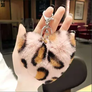 Close-up detail of the fluffy heart leopard print keychain, soft faux fur texture.