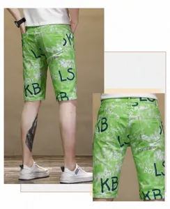 Detailed view of men's green tie-dye denim shorts featuring stylish letter print patterns.