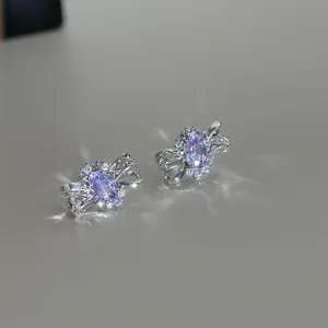 Boucles d'oreilles nœud en zirconium violet, détails pavés délicats, éclat élégant.