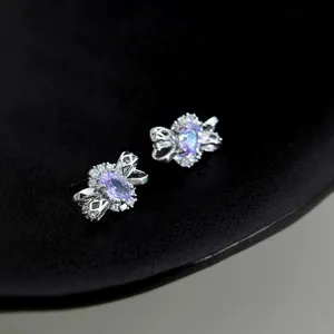 Vue détaillée de boucles d'oreilles nœud en zirconium violet étincelant argenté.