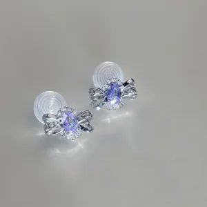 Élégantes boucles d'oreilles clip nœud en zircone violette, vue détaillée de la pierre brillante.