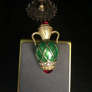 Vintage green enamel vase brooch with gold tone rhinestones and red crystal accent.