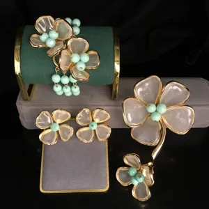 Exquisite flower jewelry set including bracelet, earrings and brooch with gold edge.