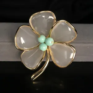 Exquisite four-leaf clover brooch with white translucent petals and green center beads.