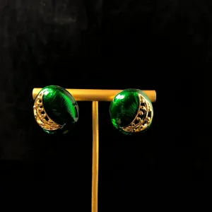 Mooie gedetailleerde close-up van vintage groene geëmailleerde oorbellen met gouden maan.