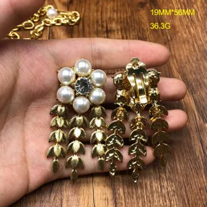 Detailed view of vintage gold-plated pearl and crystal cluster clip-on earrings with leaf tassels.