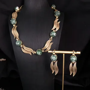 Vintage gold-toned leaf necklace and earrings set with green speckled stone beads.