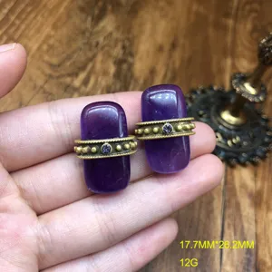 Vue de détail de boucles d'oreilles vintage en pierre violette avec anneau en métal.