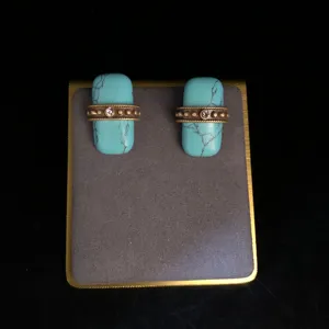 Boucles d'oreilles turquoise rétro avec une pierre rectangulaire et une bande en métal et cristal.