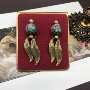 Vintage retro style alloy dangle earrings with green pink stone beads and golden leaf design.