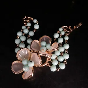 Detail shot of vintage multi-strand mint green beaded bracelet with charming flower design.