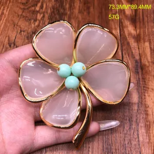 Detailed shot of gold-edged pink four-leaf clover brooch jewelry, measuring 73.3x89.4mm.